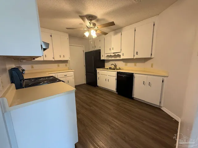 a kitchen with granite countertop a stove a sink and a refrigerator