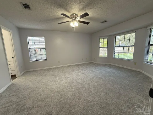 an empty room with chandelier fan