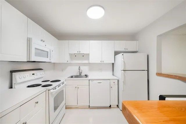 a kitchen with cabinets appliances a sink and a stove