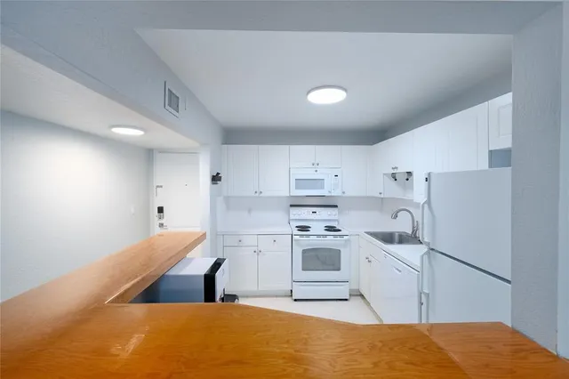 a kitchen with kitchen island sink stove and refrigerator