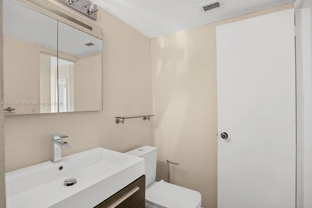 a bathroom with a granite countertop toilet and a shower