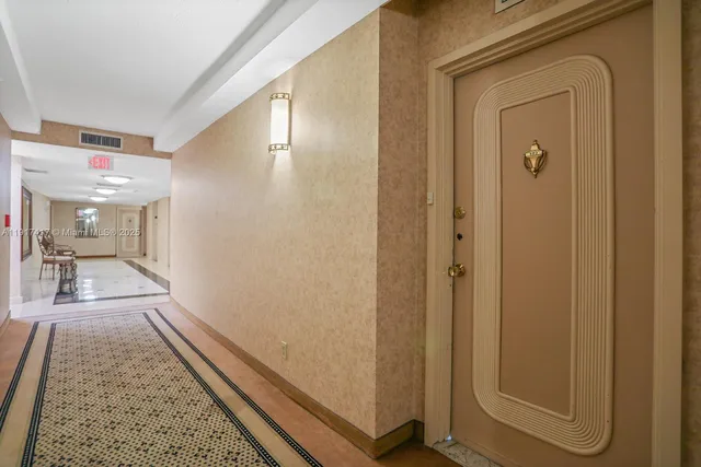 a view of a hallway with wooden floor windows and a bathroom