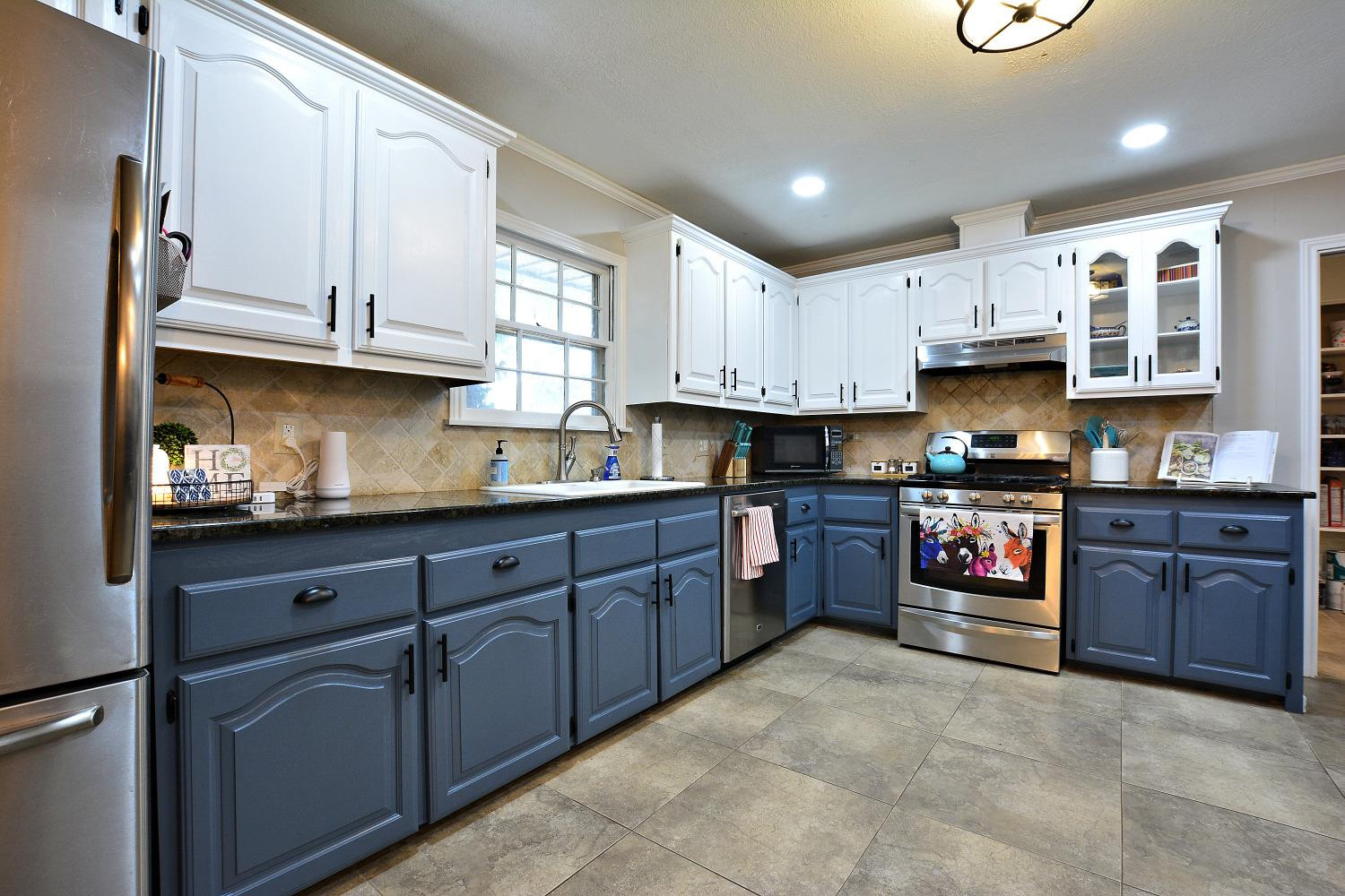 4903 17th Street Lubbock, TX 79416 - Photo 13 of 25 a kitchen with stainless steel appliances granite countertop a stove sink and cabinets