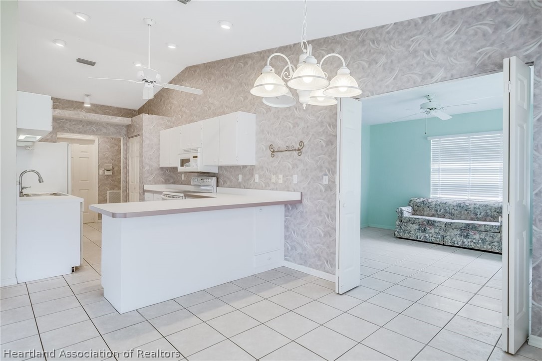 246 Tangerine Road Lake Placid, FL 33852 - Photo 12 of 36 a kitchen with kitchen island granite countertop cabinets and chandelier