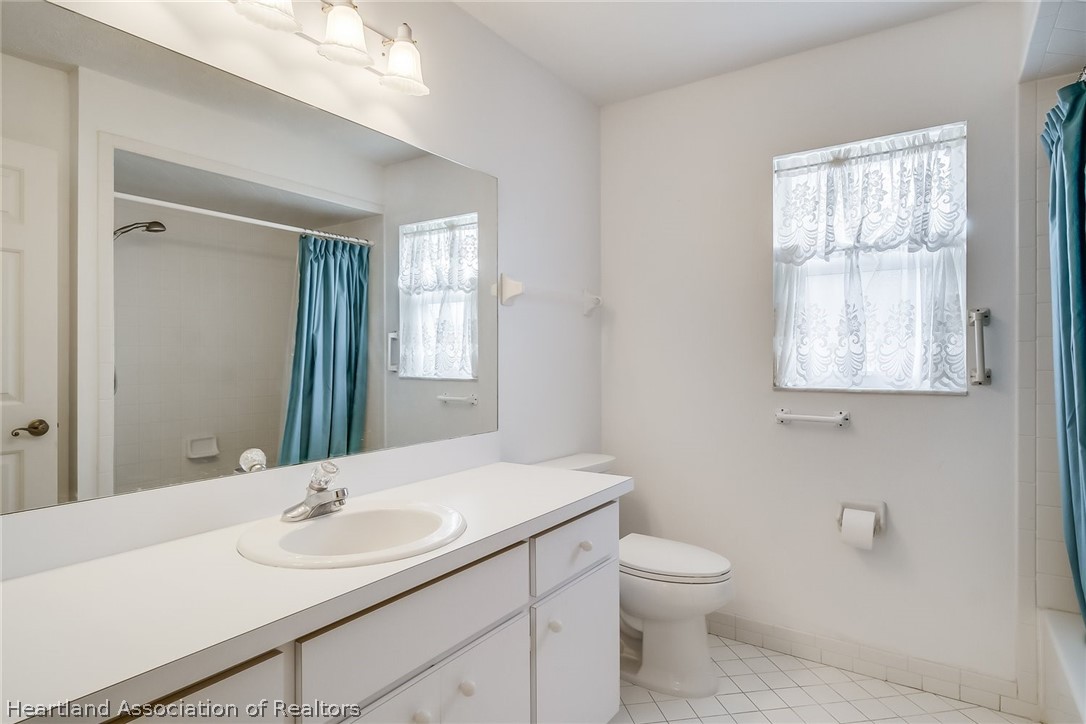 246 Tangerine Road Lake Placid, FL 33852 - Photo 25 of 36 a bathroom with a toilet a sink and mirror
