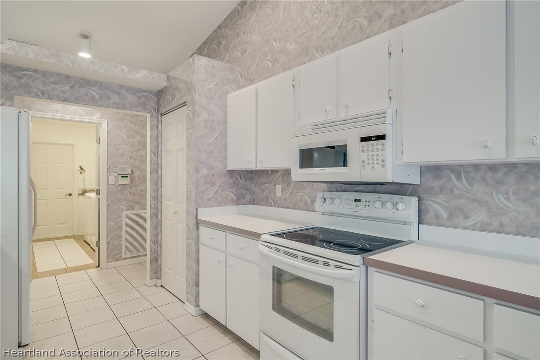 246 Tangerine Road Lake Placid, FL 33852 - Photo 26 of 36 a kitchen with white cabinets and appliances