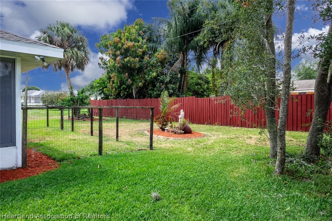 246 Tangerine Road Lake Placid, FL 33852 - Photo 31 of 36 a view of a backyard with table and chairs and potted plants and large trees