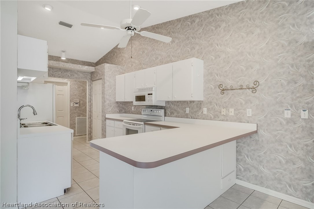 246 Tangerine Road Lake Placid, FL 33852 - Photo 10 of 36 a kitchen with a sink a stove and refrigerator