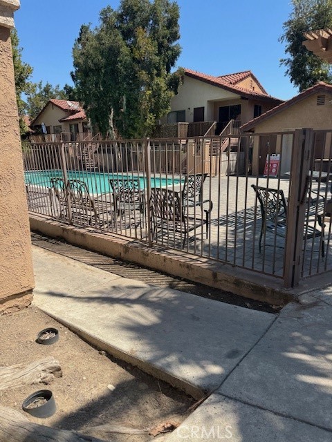 995 Margarita Drive, Unit F203 Corona, CA 92879 - Photo 11 of 12 a view of a house with a small yard and wooden fence