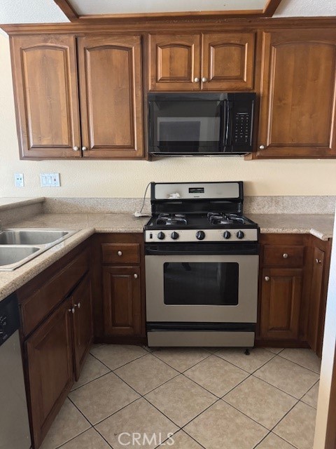 995 Margarita Drive, Unit F203 Corona, CA 92879 - Photo 4 of 12 a kitchen with granite countertop a stove top oven microwave and cabinets