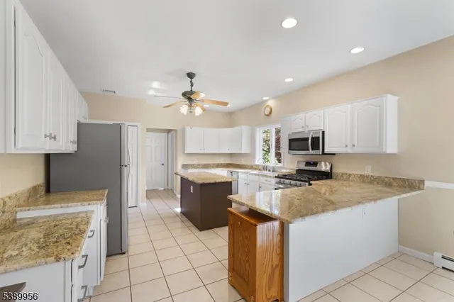 a kitchen with stainless steel appliances granite countertop a sink dishwasher stove top oven and cabinets