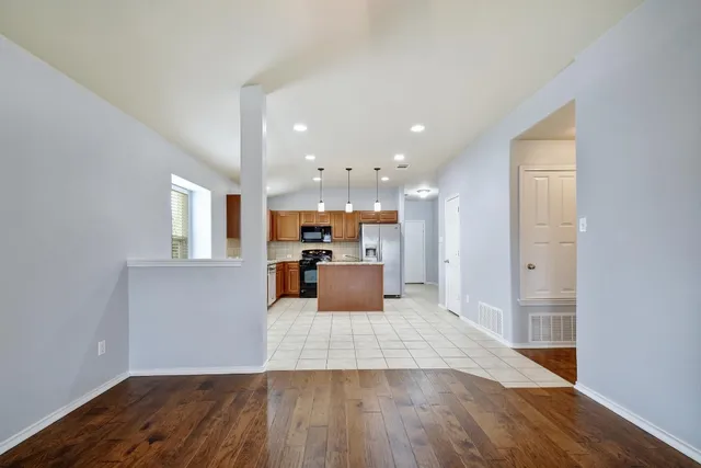 an empty room with windows and ceiling fan