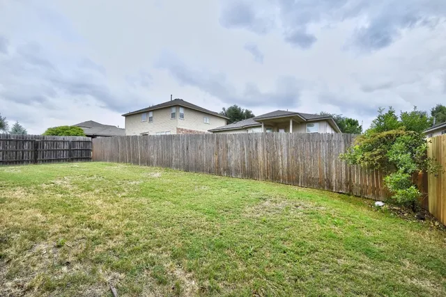 a backyard of a house with table and chairs
