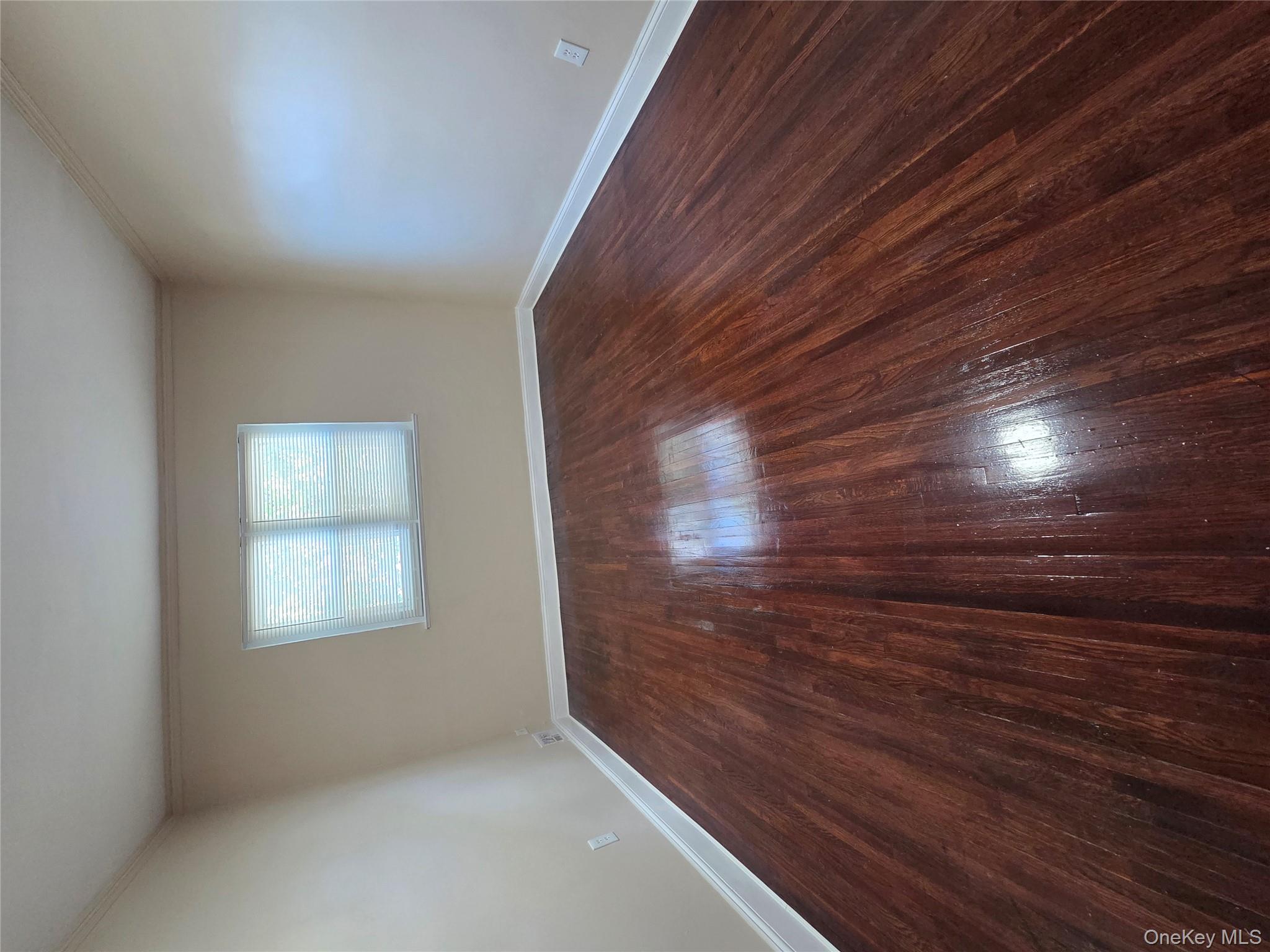 4160 Baychester Avenue Bronx, NY 10466 - Photo 13 of 24 a view of an empty room with wooden floor and a window