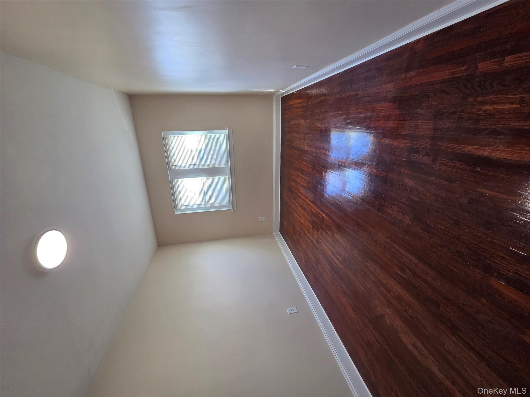 4160 Baychester Avenue Bronx, NY 10466 - Photo 18 of 24 a view of an empty room with wooden floor and a window