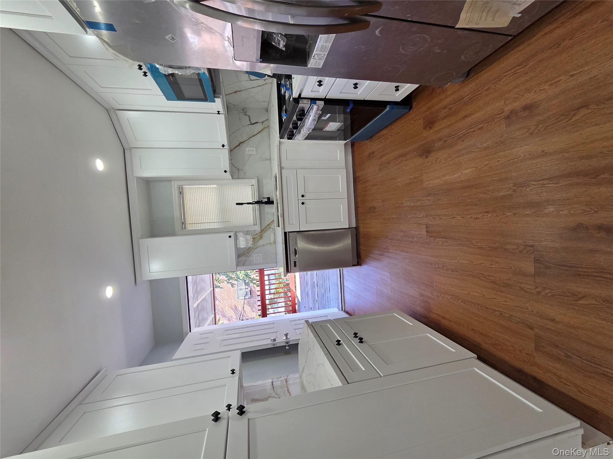 4160 Baychester Avenue Bronx, NY 10466 - Photo 9 of 24 a large kitchen with a hard wood floor stainless steel appliances and a window