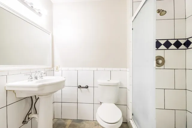 a bathroom with a sink a toilet and shower