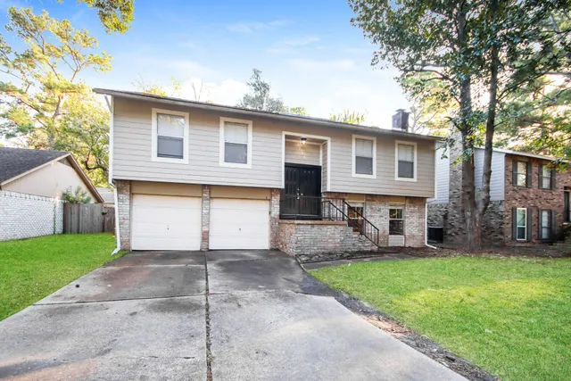 a front view of house with yard and trees in the background