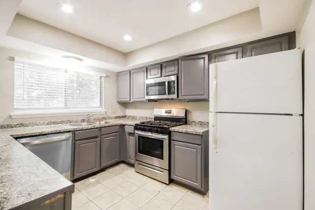 a kitchen with stainless steel appliances granite countertop a refrigerator sink stove microwave and cabinets