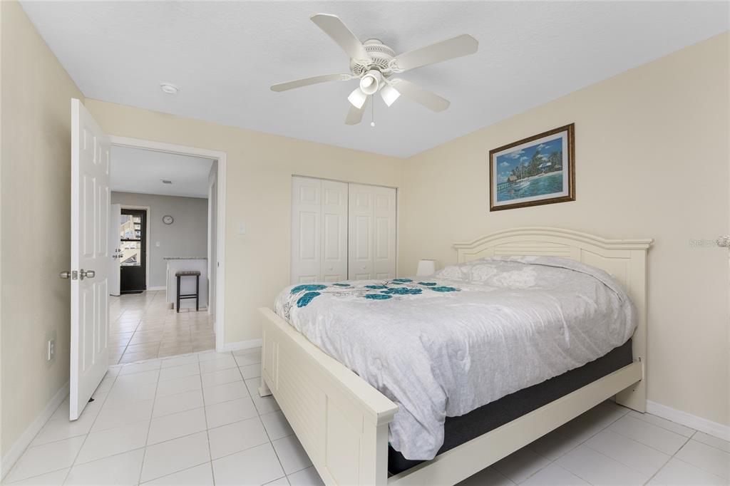 5041 North Beach Road, Unit 2A AND 2B Englewood, FL 34223 - Photo 21 of 90 a spacious bedroom with a bed and a chandelier