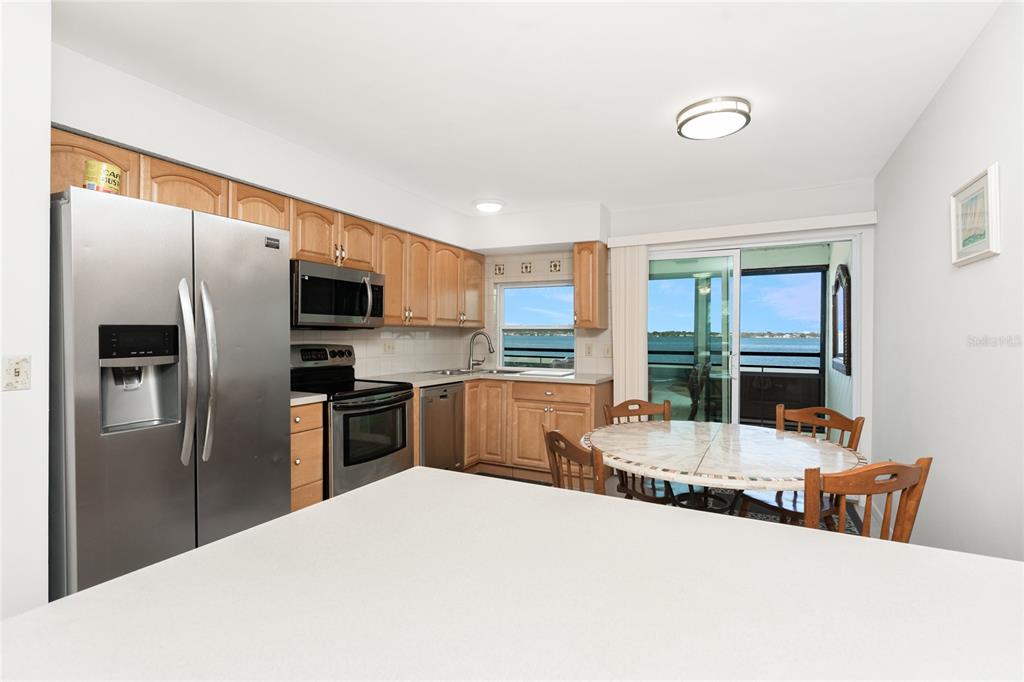 5041 North Beach Road, Unit 2A AND 2B Englewood, FL 34223 - Photo 39 of 90 a kitchen with stainless steel appliances kitchen island granite countertop a refrigerator a sink dishwasher with a dining table and chairs
