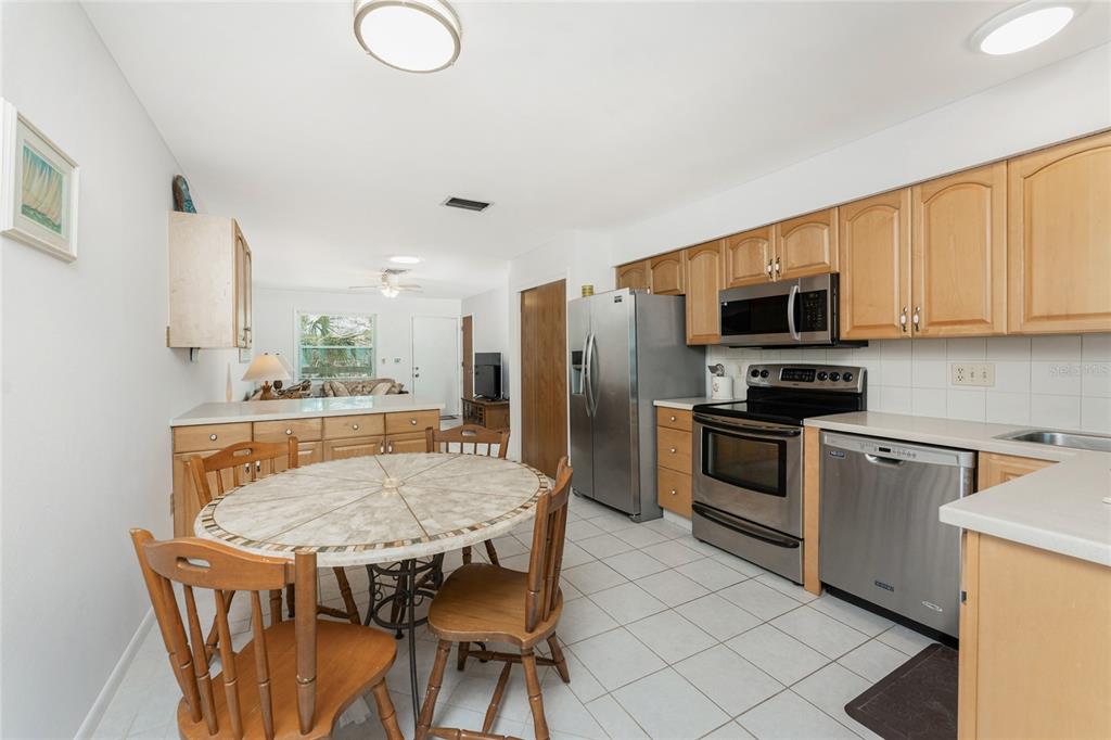 5041 North Beach Road, Unit 2A AND 2B Englewood, FL 34223 - Photo 41 of 90 a kitchen with a table chairs microwave and refrigerator