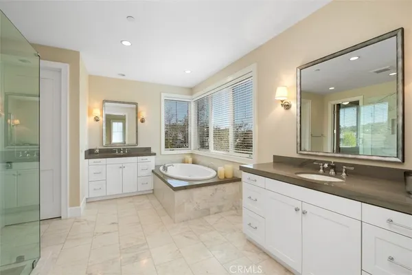 a spacious bathroom with a granite countertop tub sink and mirror