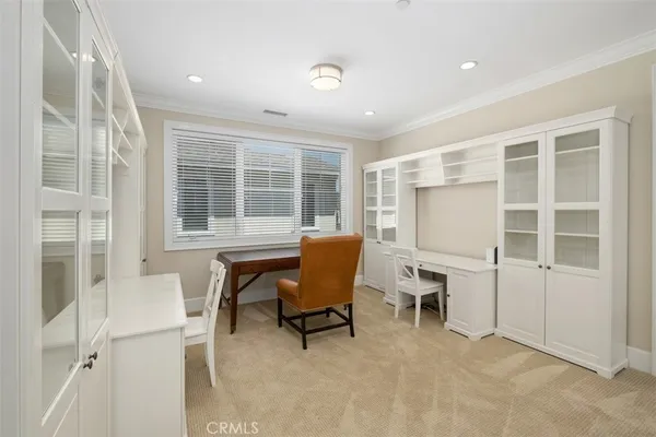 a view of a workspace with furniture and a window