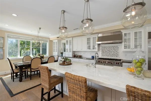 a view of a dining room and livingroom with furniture wooden floor a chandelier