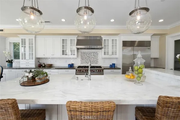 a kitchen with stainless steel appliances granite countertop a sink counter space and living room view