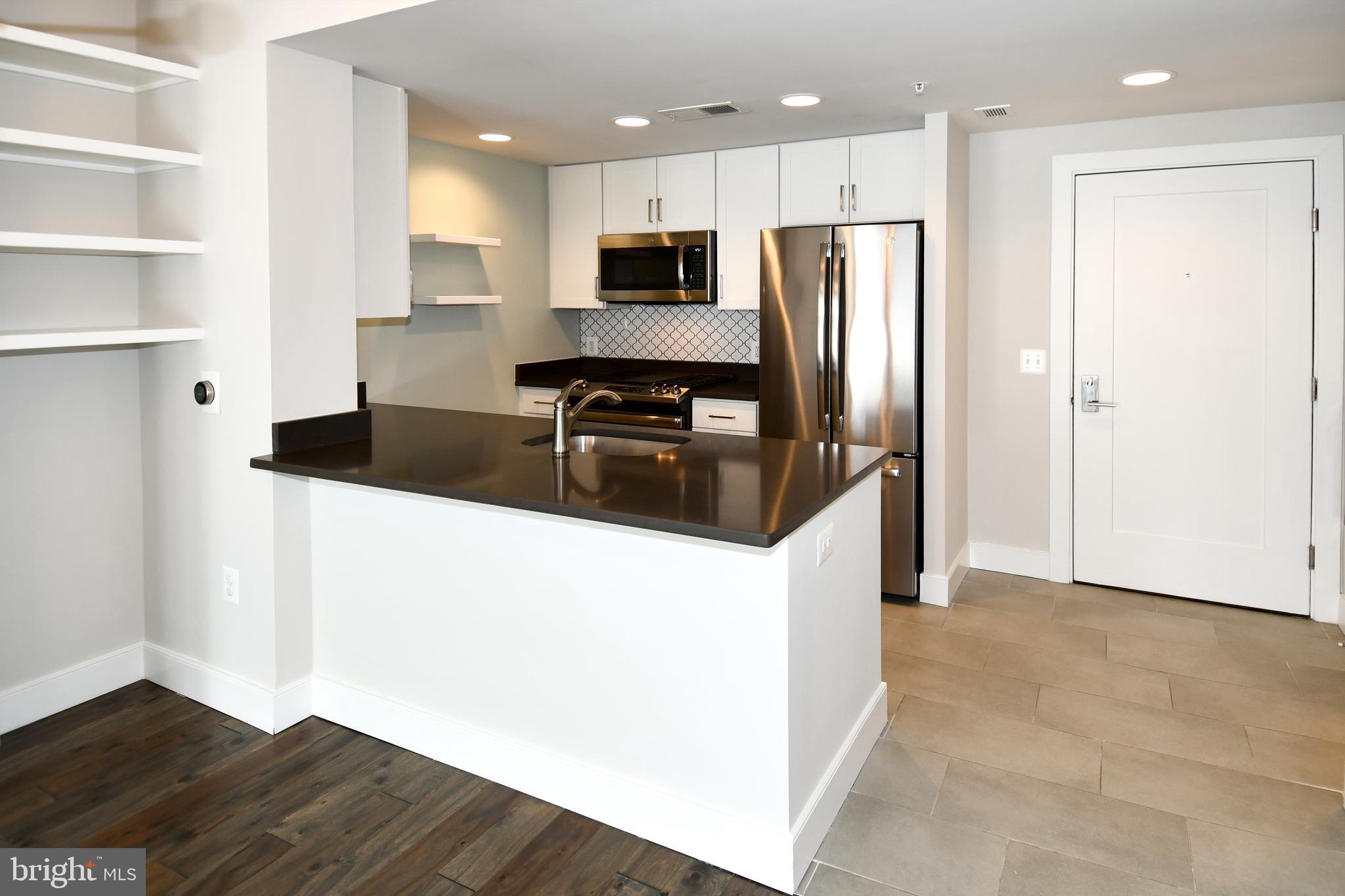 50 Florida Avenue Northeast, Unit 523 Washington, DC 20002 - Photo 11 of 38 a kitchen with granite countertop a refrigerator and a sink