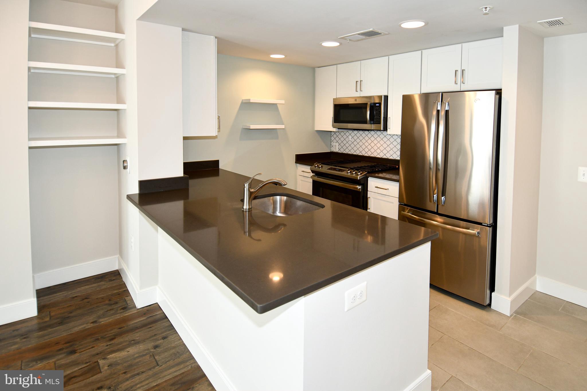 50 Florida Avenue Northeast, Unit 523 Washington, DC 20002 - Photo 12 of 38 a kitchen with stainless steel appliances granite countertop a refrigerator a sink a stove a microwave and island