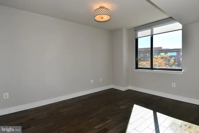 a view of a room with wooden floor and a window