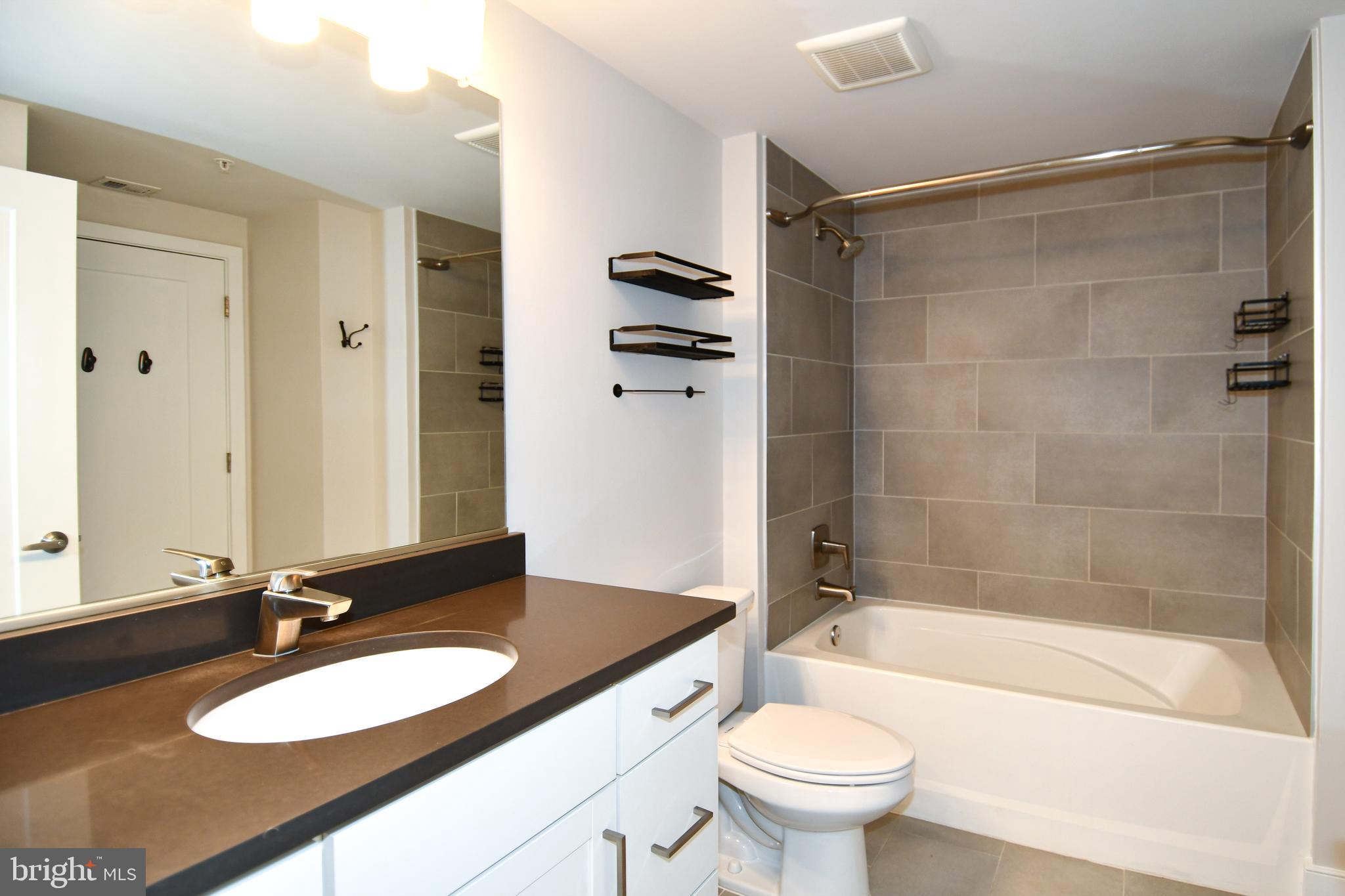 50 Florida Avenue Northeast, Unit 523 Washington, DC 20002 - Photo 24 of 38 a bathroom with a granite countertop sink toilet mirror and shower