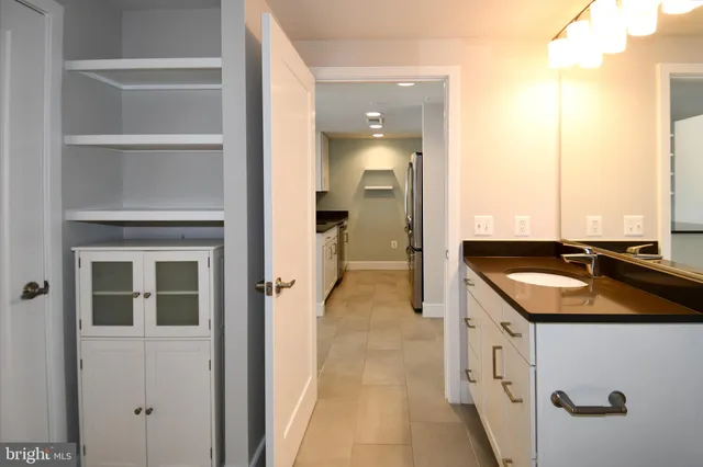 a en suite bathroom with a granite countertop sink and a mirror
