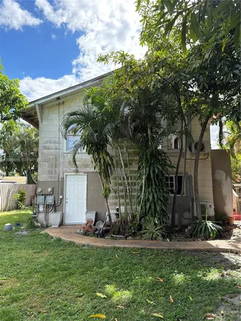 a view of a white house with a yard and plants