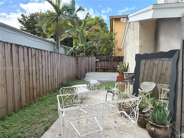 a patio with glass top table and chairs