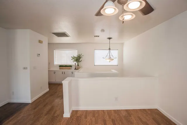 a view of a livingroom with wooden floor and a fireplace