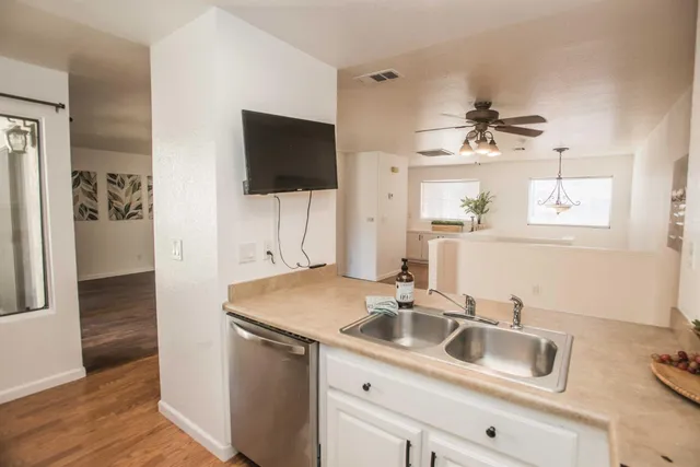 a view of a kitchen with a sink and wooden floor