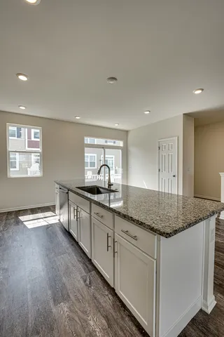 a kitchen with granite countertop white cabinets and white appliances