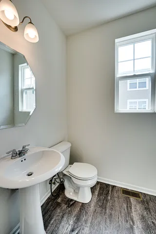 a bathroom with a sink a toilet and a window