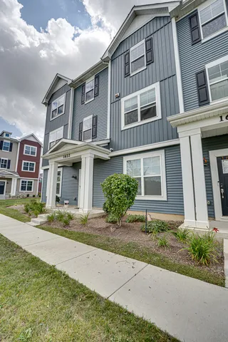 a front view of a residential apartment building with a yard