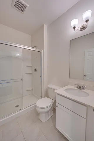 a bathroom with a granite countertop sink a toilet and shower