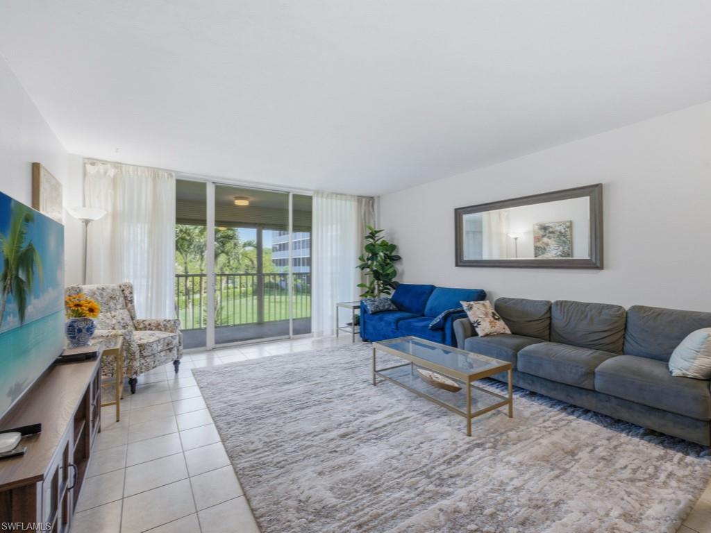 3 Bluebill Avenue, Unit 206 Naples, FL 34108 - Photo 1 of 19 a living room with furniture and a flat screen tv