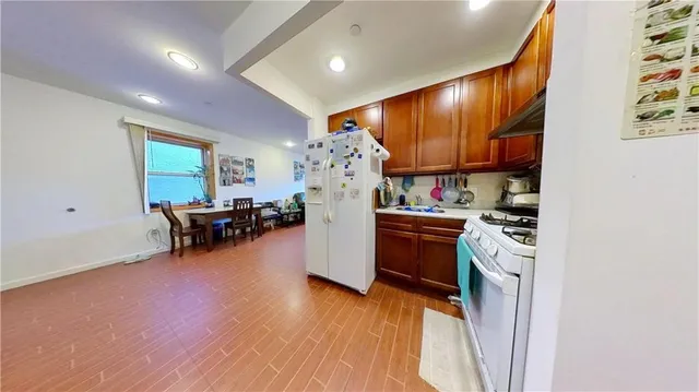 a living room with furniture a refrigerator and a flat screen tv