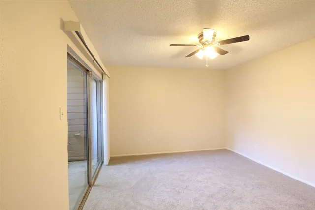 an empty room with a ceiling fan and a window