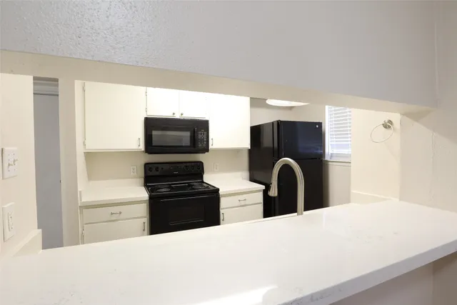 a kitchen with a refrigerator and a stove top oven with wooden floor