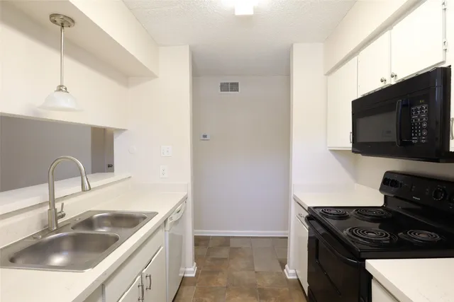 a kitchen with a sink stove and microwave