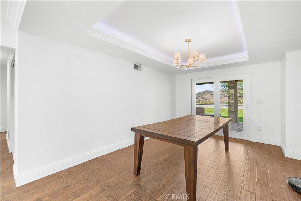 26096 Adamor Road Calabasas, CA 91302 - Photo 25 of 61 Dining room with tray ceiling, chandelier, and hidden rope accent lighting. The sliding door leads to the covered patio and offers great mountain views.