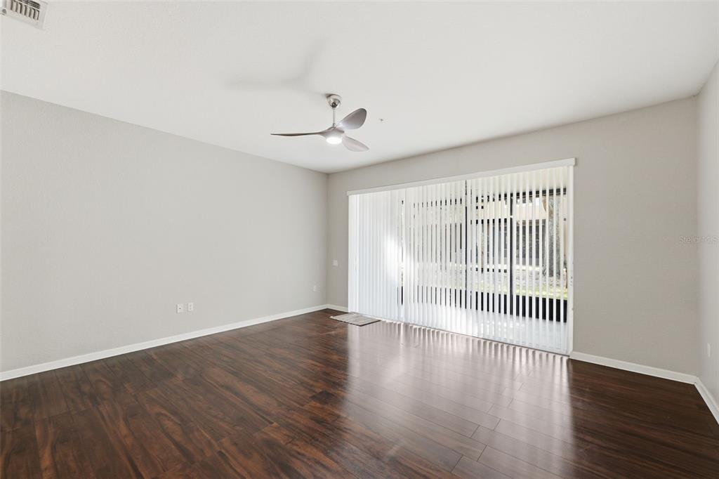 2838 Villafuerte Point, Unit 107 Orlando, FL 32835 - Photo 12 of 27 an empty room with wooden floor and windows